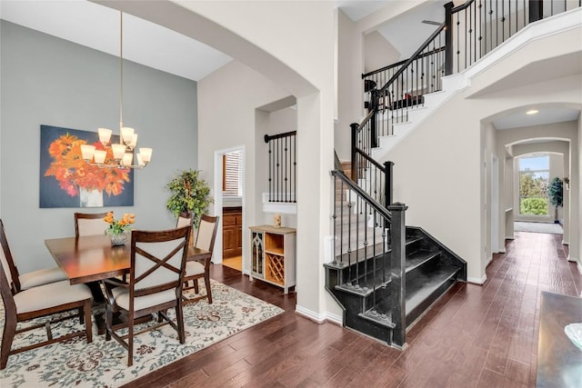 3925 Good Night Trl, Leander, TX 78641 - dining area with arched walkways, a high ceiling, wood finished floors, and a chandelier
