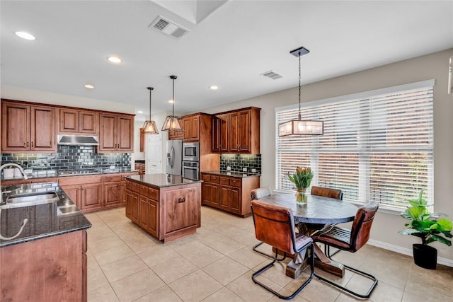 3925 Good Night Trl, Leander, TX 78641 - kitchen with under cabinet range hood, appliances with stainless steel finishes, backsplash, a kitchen island, and pendant lighting