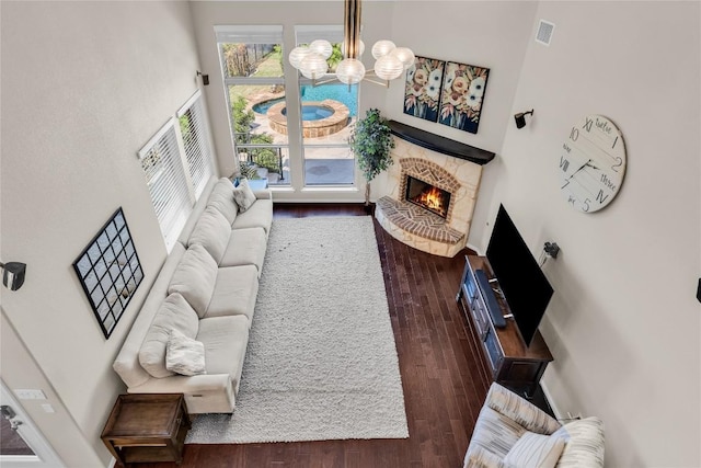 3925 Good Night Trl, Leander, TX 78641 - living area featuring a chandelier, wood finished floors, a lit fireplace, and a high ceiling