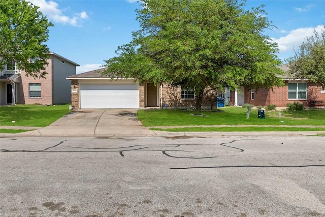 804 Lavaca Loop, Elgin, TX 78621 - view of property hidden behind natural elements featuring an attached garage, concrete driveway, a front yard, and brick siding