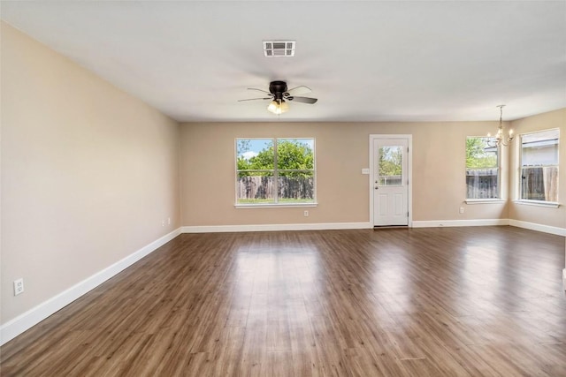 804 Lavaca Loop, Elgin, TX 78621 - unfurnished living room featuring ceiling fan, a chandelier, and dark wood-style floors