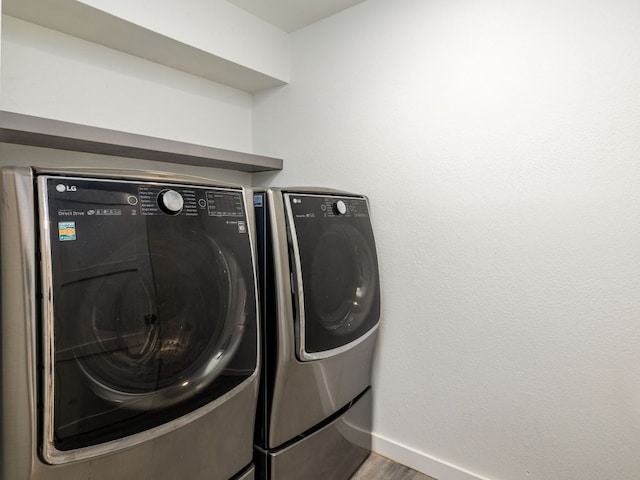 8004 Osborne Dr, Austin, TX 78729 - laundry area featuring washer and dryer, wood finished floors, and baseboards