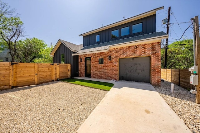 3306 Larry Ln Unit B, Austin, TX 78722 - view of front of house featuring board and batten siding, driveway, a gate, brick siding, and an attached garage