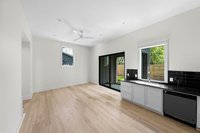 3306 Larry Ln Unit B, Austin, TX 78722 - kitchen featuring dishwasher, dark countertops, light wood-style floors, and backsplash