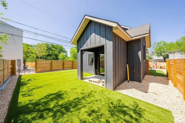 3306 Larry Ln Unit B, Austin, TX 78722 - back of house featuring board and batten siding, a fenced backyard, and roof with shingles