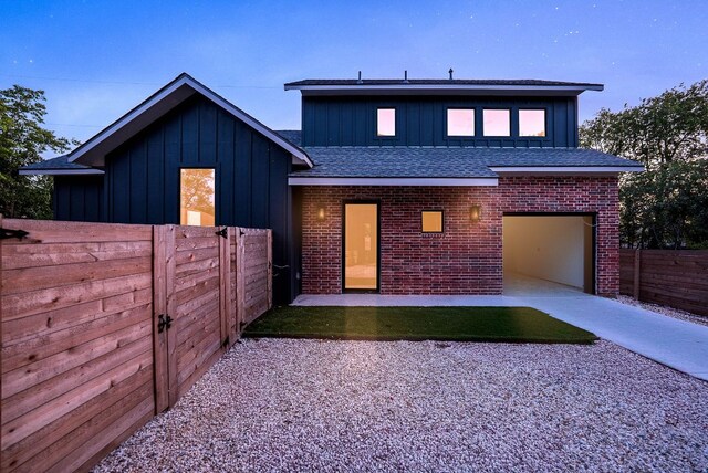 3306 Larry Ln Unit B, Austin, TX 78722 - view of front facade featuring board and batten siding, concrete driveway, brick siding, and roof with shingles