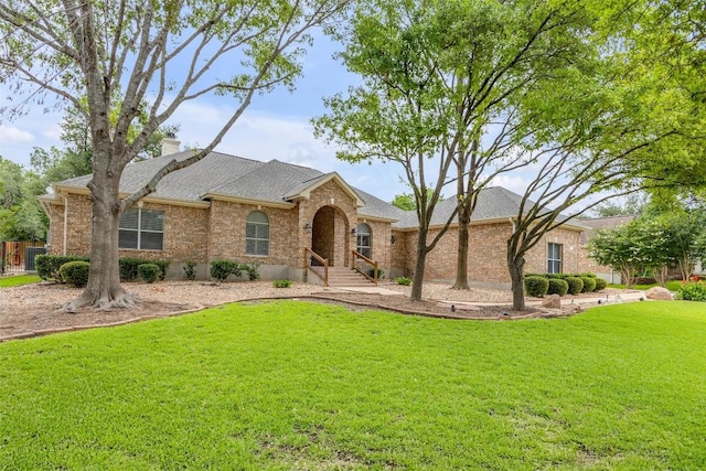 3028 Indigo Trl, Round Rock, TX 78665 - view of front of home featuring a front yard, a chimney, brick siding, and a shingled roof