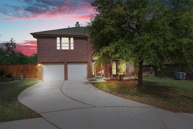 traditional home featuring brick siding, central AC, a front yard, concrete driveway, and an attached garage