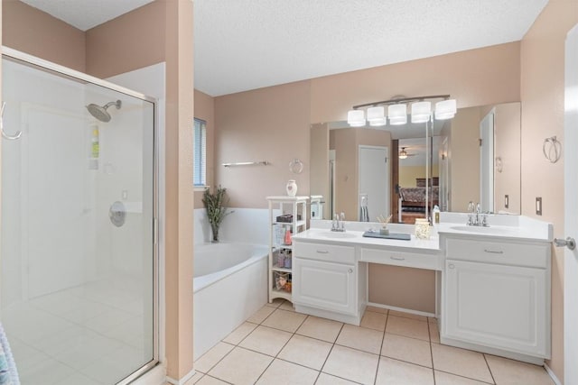 full bath with tile patterned flooring, double vanity, a sink, a stall shower, and a garden tub
