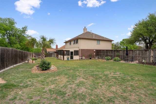 view of yard with a sunroom and a fenced backyard