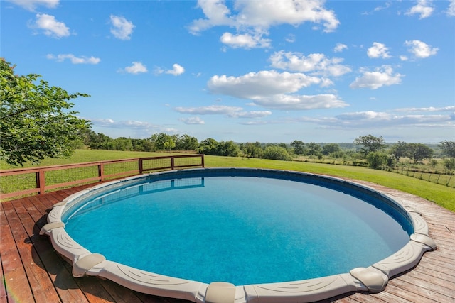 outdoor pool featuring a lawn and a deck