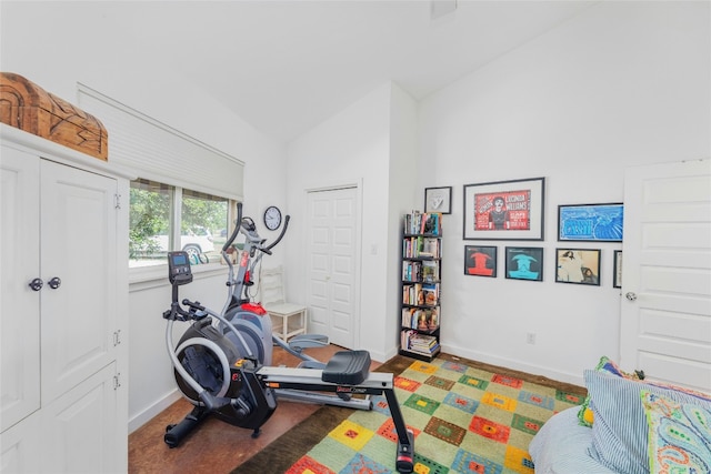 workout area featuring baseboards and lofted ceiling