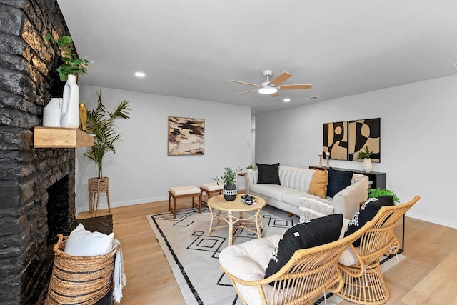 305 Pecan Ln, Round Rock, TX 78664 - living area featuring light wood-style flooring, baseboards, a stone fireplace, and ceiling fan