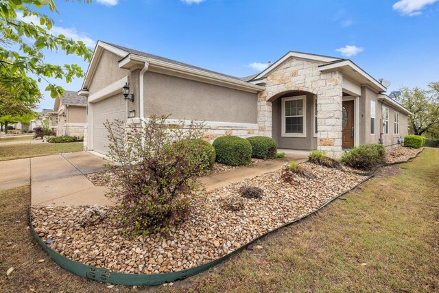 839 Salado Creek Ln, Georgetown, TX 78633 - view of front of property featuring a front lawn, stone siding, stucco siding, concrete driveway, and an attached garage