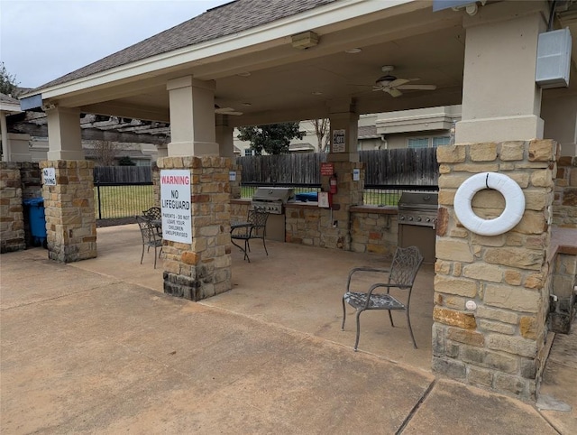 view of patio with exterior kitchen, fence, area for grilling, and ceiling fan