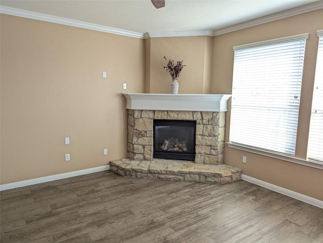 unfurnished living room featuring a fireplace, ornamental molding, wood finished floors, a healthy amount of sunlight, and baseboards