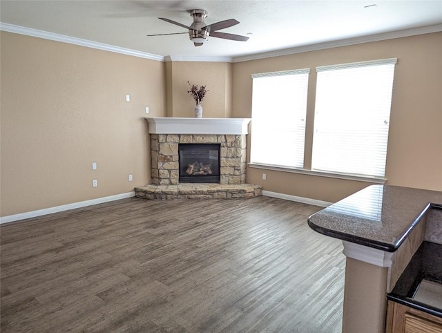 living area featuring a fireplace, baseboards, ornamental molding, and ceiling fan