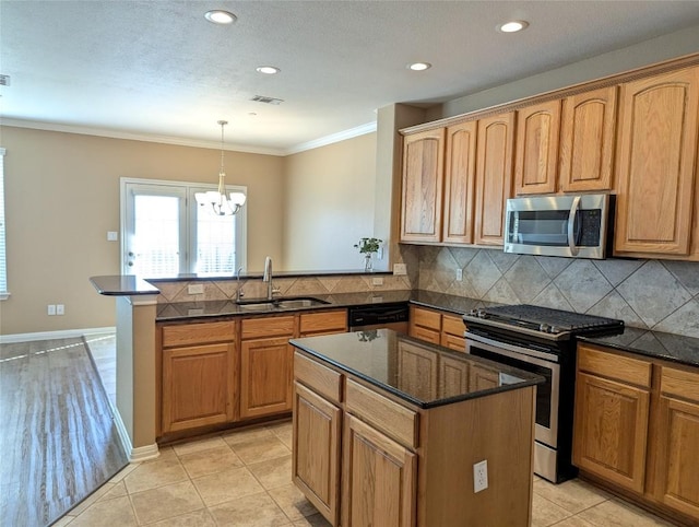 kitchen with a peninsula, backsplash, visible vents, stainless steel appliances, and a sink