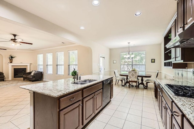 2920 Agave Loop, Round Rock, TX 78681 - kitchen with black appliances, light tile patterned floors, ceiling fan, a fireplace, and dark brown cabinetry