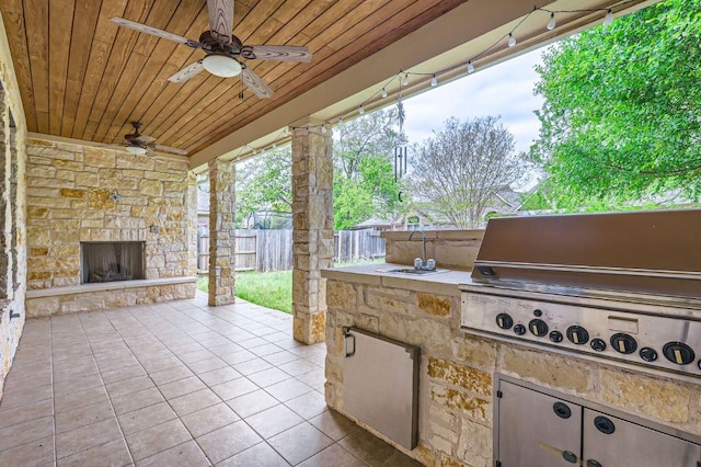 2920 Agave Loop, Round Rock, TX 78681 - fenced backyard featuring an outdoor stone fireplace, exterior kitchen, ceiling fan, and a patio area