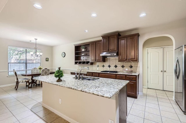 2920 Agave Loop, Round Rock, TX 78681 - kitchen with under cabinet range hood, stainless steel fridge, open shelves, light tile patterned floors, and recessed lighting
