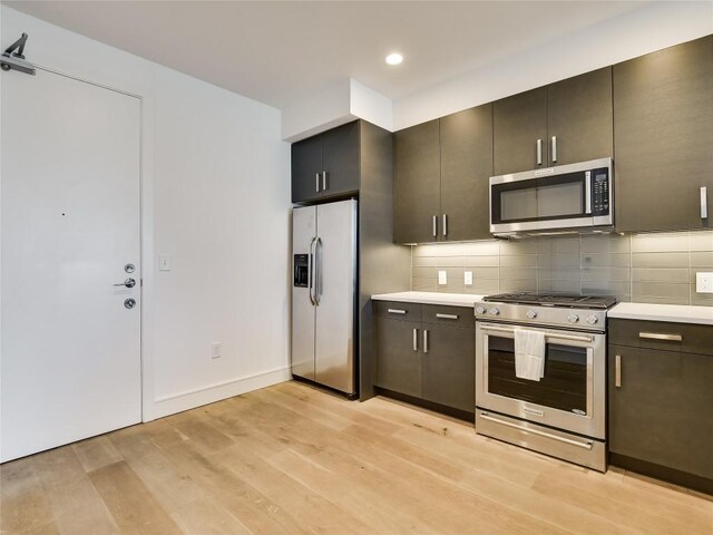 222 W Ave Unit 1907, Austin, TX 78701 - kitchen featuring stainless steel appliances, light wood-style floors, light countertops, backsplash, and recessed lighting