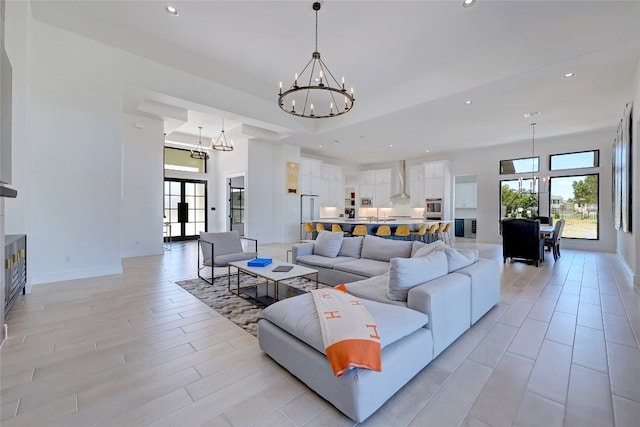living area with baseboards, a notable chandelier, recessed lighting, and a healthy amount of sunlight