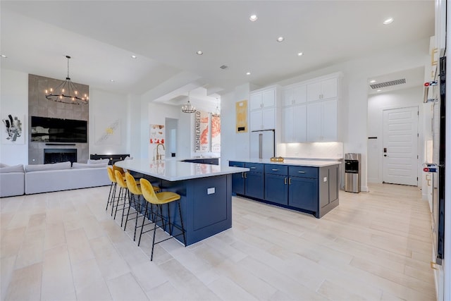 kitchen featuring light countertops, a chandelier, a kitchen bar, a large island, and open floor plan