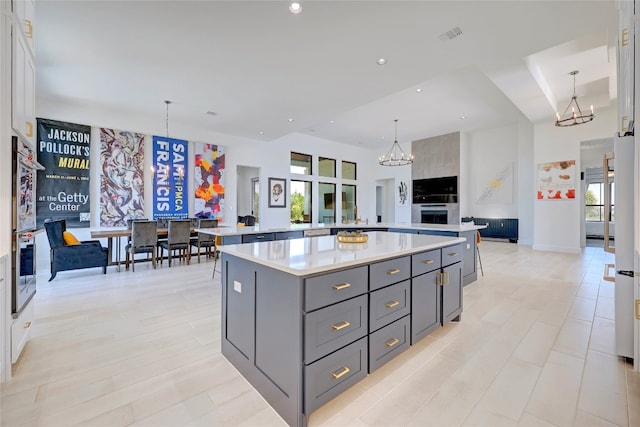 kitchen with a large island, light countertops, and a notable chandelier