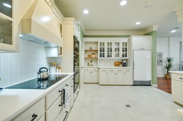 1174 Royal Eagle Dr, Fischer, TX 78623 - kitchen featuring paneled fridge, custom range hood, black electric stovetop, ornamental molding, and decorative backsplash