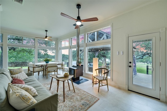 1174 Royal Eagle Dr, Fischer, TX 78623 - sunroom featuring healthy amount of natural light, crown molding, a wood stove, baseboards, and tile patterned flooring
