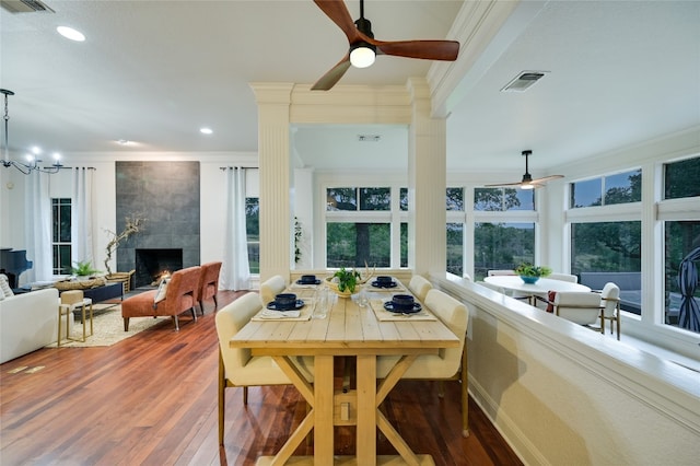 1174 Royal Eagle Dr, Fischer, TX 78623 - dining space with a ceiling fan, crown molding, wood finished floors, a fireplace, and recessed lighting