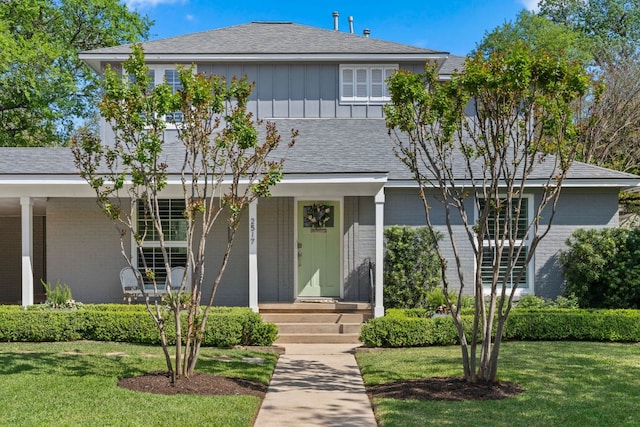 2517 Exposition Blvd, Austin, TX 78703 - view of front of property with brick siding, board and batten siding, a front yard, and covered porch