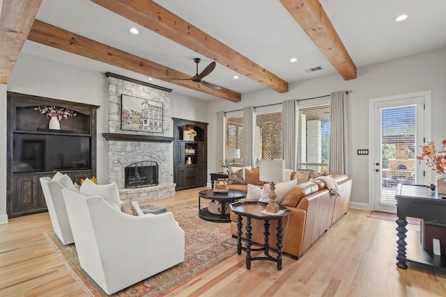 436 Santaluz Path, Austin, TX 78732 - living area featuring ceiling fan, baseboards, wood finished floors, beam ceiling, and a stone fireplace