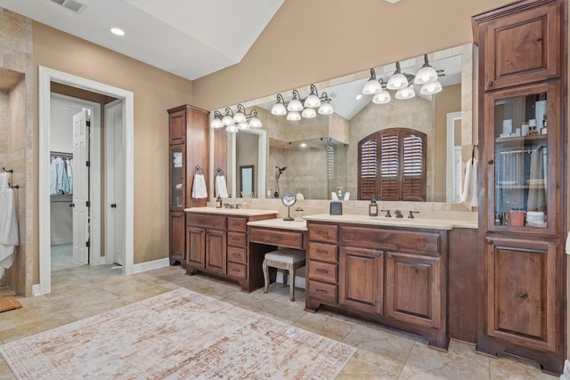 bathroom with a stall shower, vaulted ceiling, a sink, and two vanities