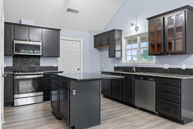 kitchen with visible vents, light wood finished floors, appliances with stainless steel finishes, a sink, and vaulted ceiling