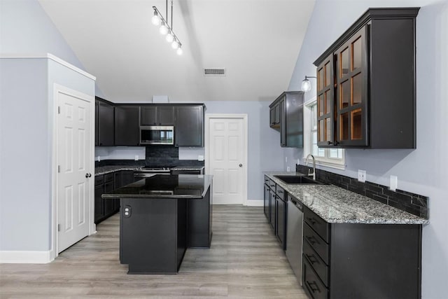 1234 County Road 135, Lincoln, TX 78948 - kitchen with stainless steel appliances, a sink, lofted ceiling, tasteful backsplash, and dark stone countertops