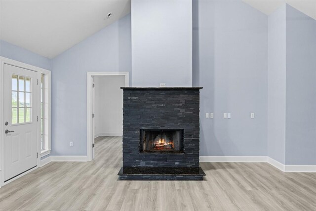 unfurnished living room with baseboards, a fireplace, and wood finished floors