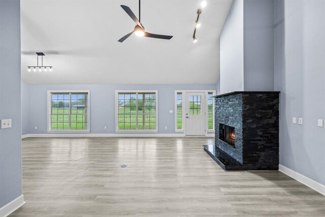 unfurnished living room featuring baseboards, lofted ceiling, wood finished floors, and a ceiling fan