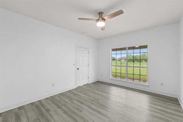 empty room featuring baseboards, ceiling fan, and wood finished floors
