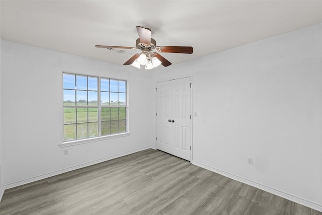 1234 County Road 135, Lincoln, TX 78948 - unfurnished room with wood finished floors, a ceiling fan, and baseboards