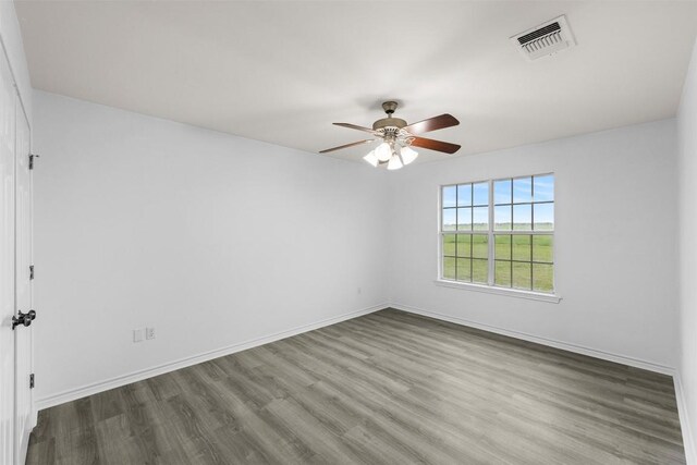 unfurnished room with baseboards, ceiling fan, visible vents, and wood finished floors