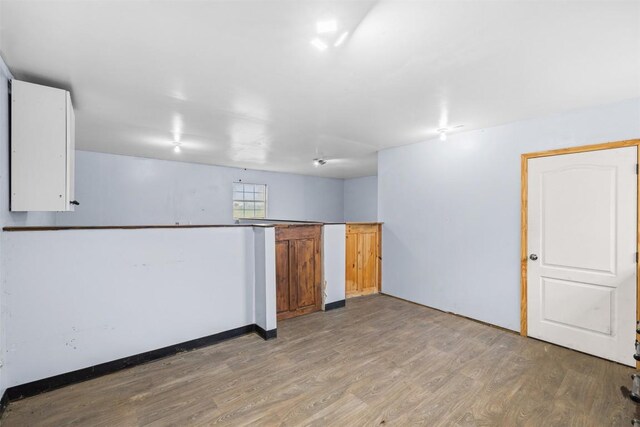 interior space featuring baseboards and wood finished floors