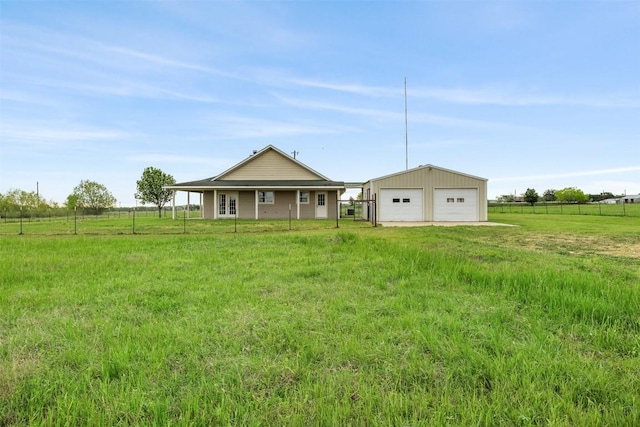 exterior space featuring a garage, fence, a front yard, and an outbuilding