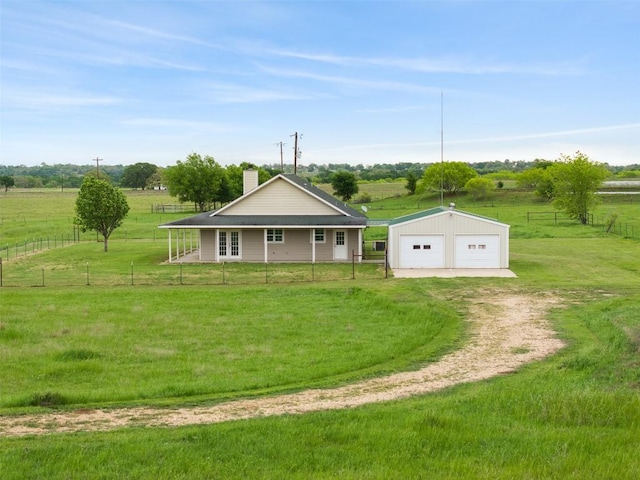 view of front of property with a front lawn, an outbuilding, fence, and a detached garage