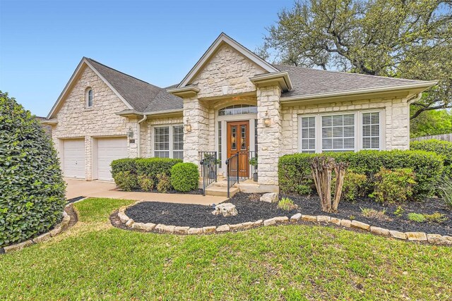 11100 Comiso Pala Path, Austin, TX 78726 - view of front facade with stone siding, roof with shingles, a front lawn, and concrete driveway