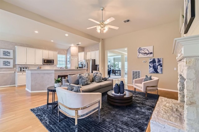 living area with visible vents, light wood-style flooring, baseboards, recessed lighting, and a ceiling fan