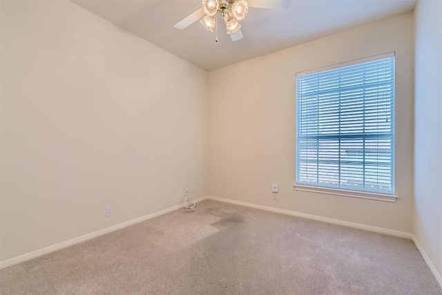 carpeted empty room featuring baseboards and ceiling fan