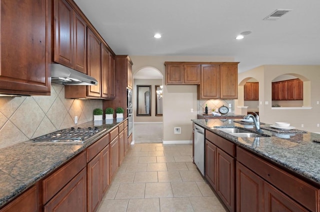 17920 Silent Harbor Loop, Pflugerville, TX 78660 - kitchen with under cabinet range hood, a sink, appliances with stainless steel finishes, arched walkways, and baseboards