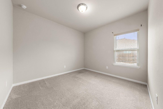 unfurnished room featuring baseboards and carpet floors
